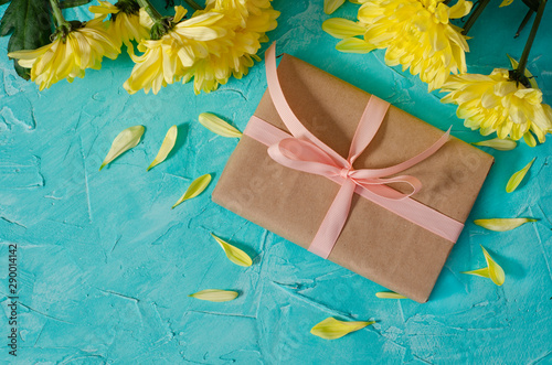 gift box with yellow flowers and petals on a blue background