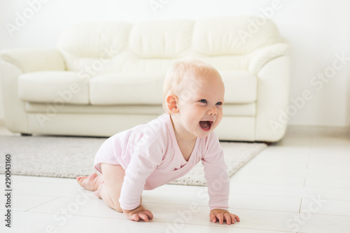 Smiling crawling baby girl at home on floor