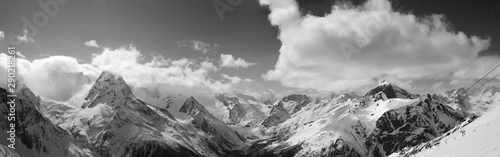 Black and white panorama of snowy sunlit mountains