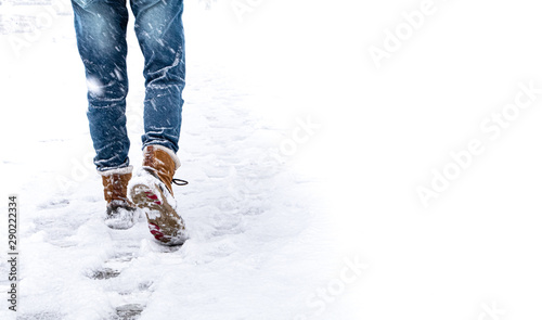 A woman wear winter boot walking carefully on road fully snow. Concept of living life with confidence and take care every steps of moving forward to make sure life safe. Free Copy space