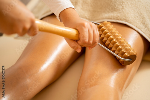 Anti cellulite massage with wooden tool closeup 
