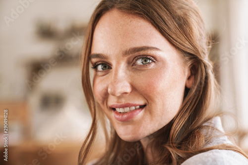 Smiling cheerful beautiful redhead woman indoors at home.