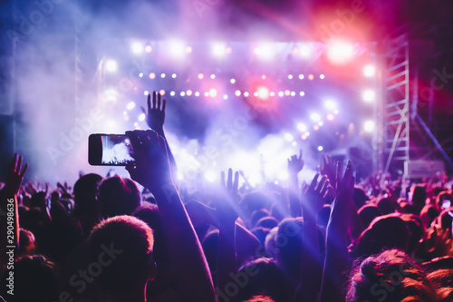 People taking photographs with touch smart phone during a music entertainment public concert