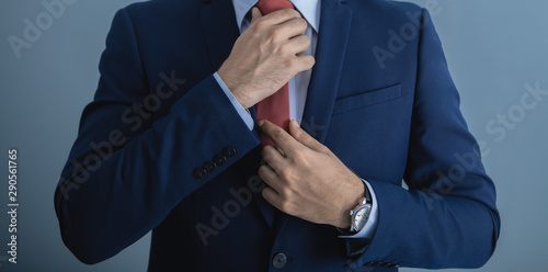 businessman in suit straightens tie