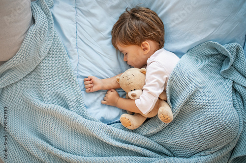 Sweet little boy sleeps with a toy. Young boy in bed sleeping and hug teddy bear. Little boy, big dreamer. It’s bedtime for baby and bear. With teddy close by he has the softest sweetest dreams