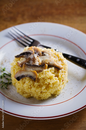Couscous with mushrooms in cream sauce. Vertical image