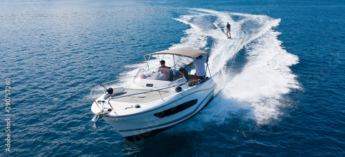Speedboat with wakeboard rider on open sea