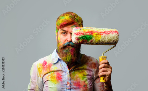 Painter man. Professional painter, decorator. Repair, building concept. Room painting job. Handsome bearded worker with paint roller. Builder worker, repairman, tradesman, handyman with paint roller.