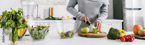 panoramic shot of woman preparing salad in kitchen