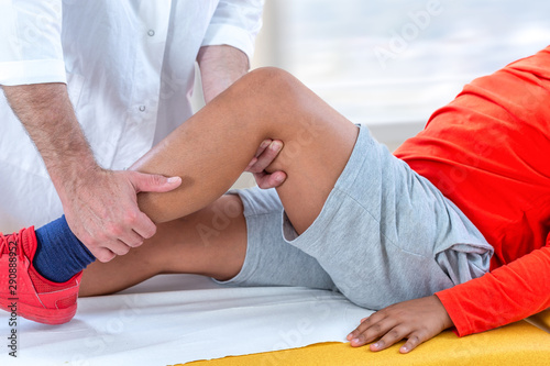 Doctor examining boy leg because of knee problem symptomset hospital