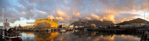 wide panorama of Cape Town cloudy Table Mountain, Signal Hill from Waterfront at sunset. Sea, harbour and boats