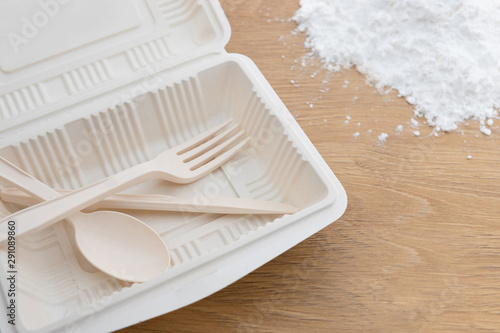 Biodegradable plastic spoon, fork and knife made from starch on wooden background