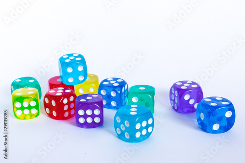 Rozrzucone kolorowe kostki do gry na białym tle, zbliżenie kostek do gry
