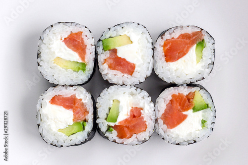 Close up fresh prepared sushi rolls with avocado, red fish salmon and whit cheese filadelfia in black nori. Top view