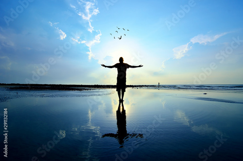 Silhouette of Man Raising His Hands or Open arms when sun rising up