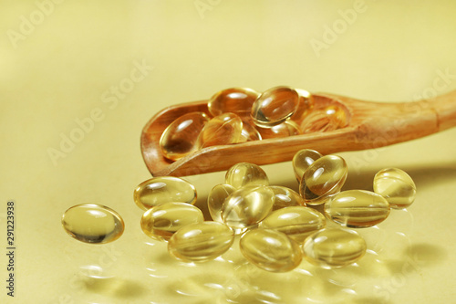 fish oil capsules isolated on yellow background