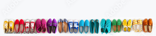 A lot of colored youth women's shoes without heels. Sneakers, slippers, ballet shoes. White background.
