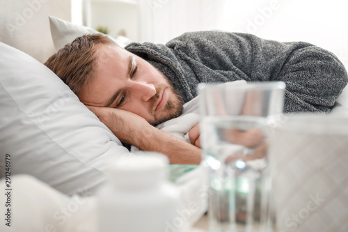 Man ill with flu lying in bed
