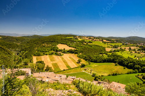 The green Umbrian hills seen from the top of the city of Amelia, in Umbria. The rich vegetation, cultivated fields, the clear blue sky in summer. An avenue of cypresses. Mountains in the background.