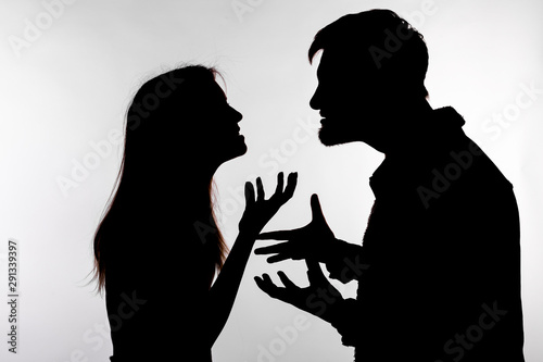 Aggression and abuse concept - man and woman expressing domestic violence in studio silhouette isolated on white background.