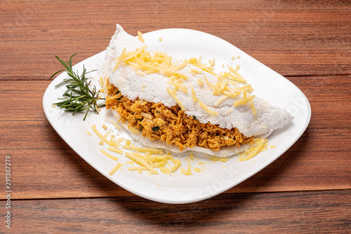 Tapioca filled with chiken breast and cheese on wooden background. Flatbread made from cassava (also known as casabe, bammy, beiju, bob, biju).