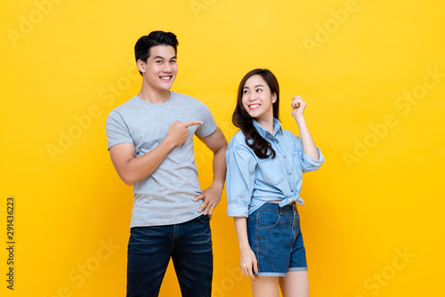 Asian handsome man pointing finger at smiling woman