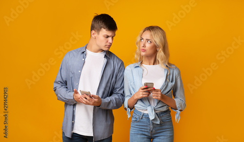 Jealous guy looking at girlfriend's cellphone, reading her messages