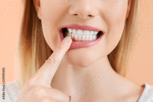 Beautiful woman with healthy teeth on color background, closeup