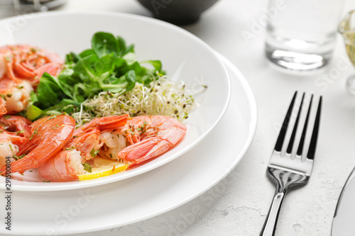 Plate with tasty shrimps on table