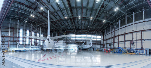 Passenger jet planes under maintenance. Checking mechanical systems for flight operations. Panorama of aircrafts in the hangar