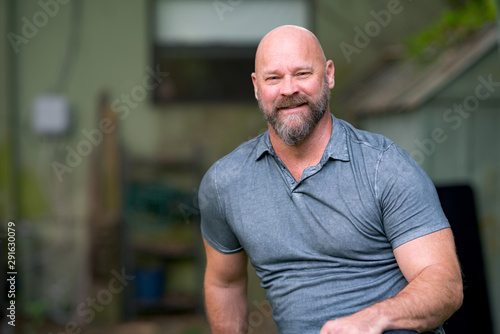 Photo of a handsome man with a bears smiling at camera