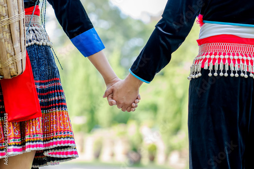 Happy young couple walking hand in hand and promised to take care of each other with love and caring. Lovers, Friendship and Valentine concept. Hmong couple.