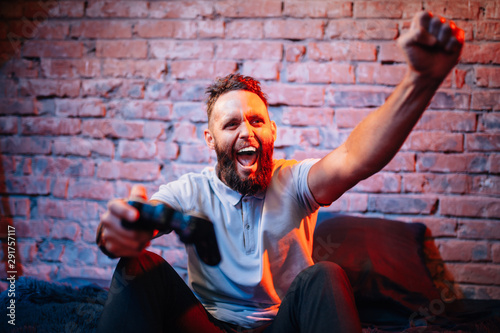 Emotional guy playing video game at home. Concept of gaming and technology. Relax