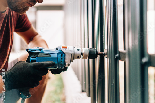 Man working with an electric screwdriver on the construction site