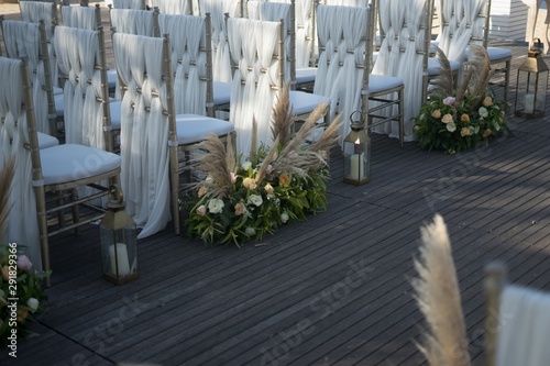 Shot of decorated white chairs for a wedding reception in the evening