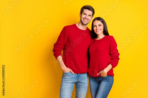 Portrait of lovely man and woman hug smile wear red pullover denim jeans stand isolated over yellow background