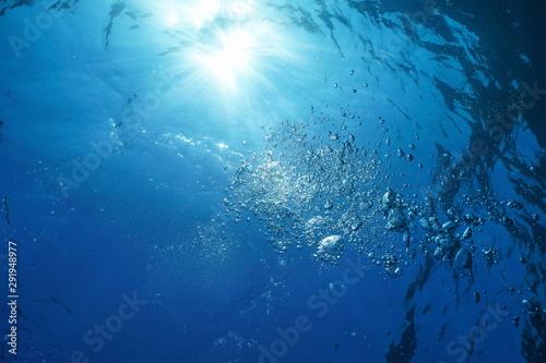 Sunlight underwater surface with air bubbles