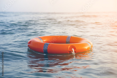 Orange lifebuoy in sea on water. Life ring floating on top of water. Life ring in ocean.Toning.