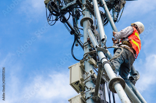 technician working on high telecommunication tower,worker wear Personal Protection Equipment for working high risk work,inspect and maintenance equipment on high tower.