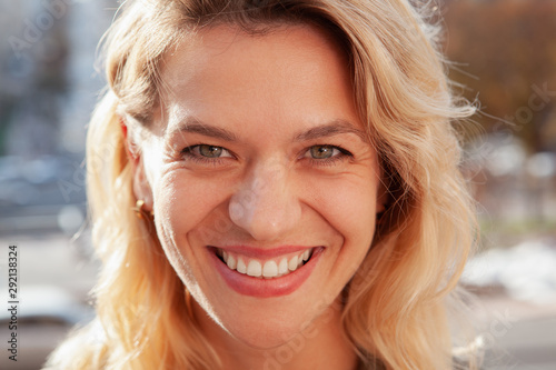 Close up of a gorgeous happy mature woman smiling to the camera. Cropped shot of face of a cheerful attractive woman laughing