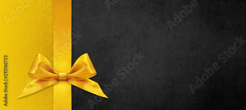 black gift card with golden ribbon bow, black friday concept