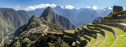 Panoramic view of Machu Picchu ruins in Peru. Behind we can appreciate big and beautiful mountains full of green vegetation. Archaeological site, UNESCO World Heritage
