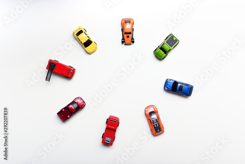 Overhead shot of child's toy cars arranged on a white table, no people in shot