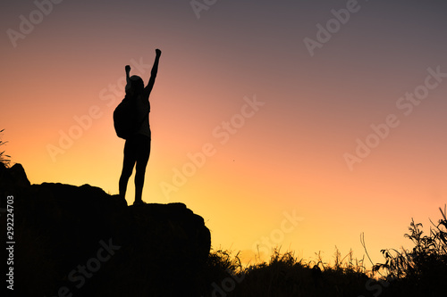 Goal setting. Female climber reaching top of mountain 