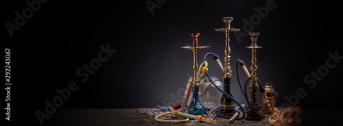 Rustic handmade hookah and arabic tea for relaxation in a dark moody room, rustic decoration, smoke and shisha components