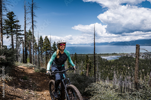 female mountain biker with lake and clouds