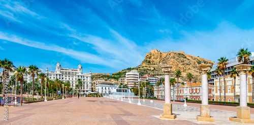 Houses on the promenade of Alicante, Spain in the Baroque style among palm trees, Pinnacles and spiers