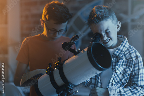 Smart kids using a telescope and stargazing