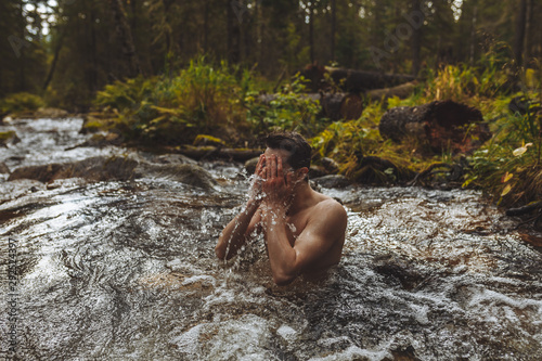 relaxed young man swimming in the cold river, healthy lifestyle, health care, wellness. close up photo