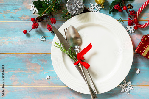 Christmas table setting. Festive plate and cutlery with decor on festive table. Top view flat lay. Free space for your text.